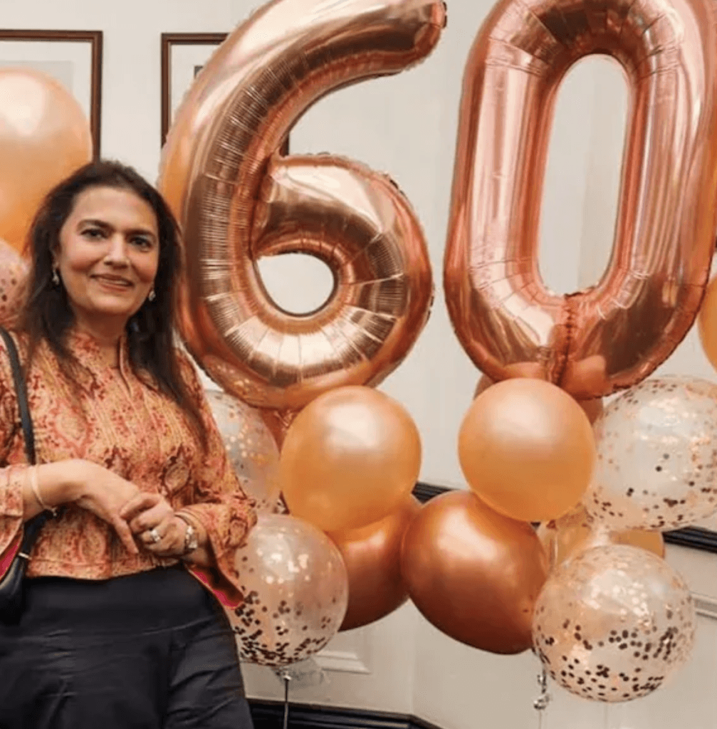Suchithra Mohanlal with a large '60' written in balloons visible in the frame